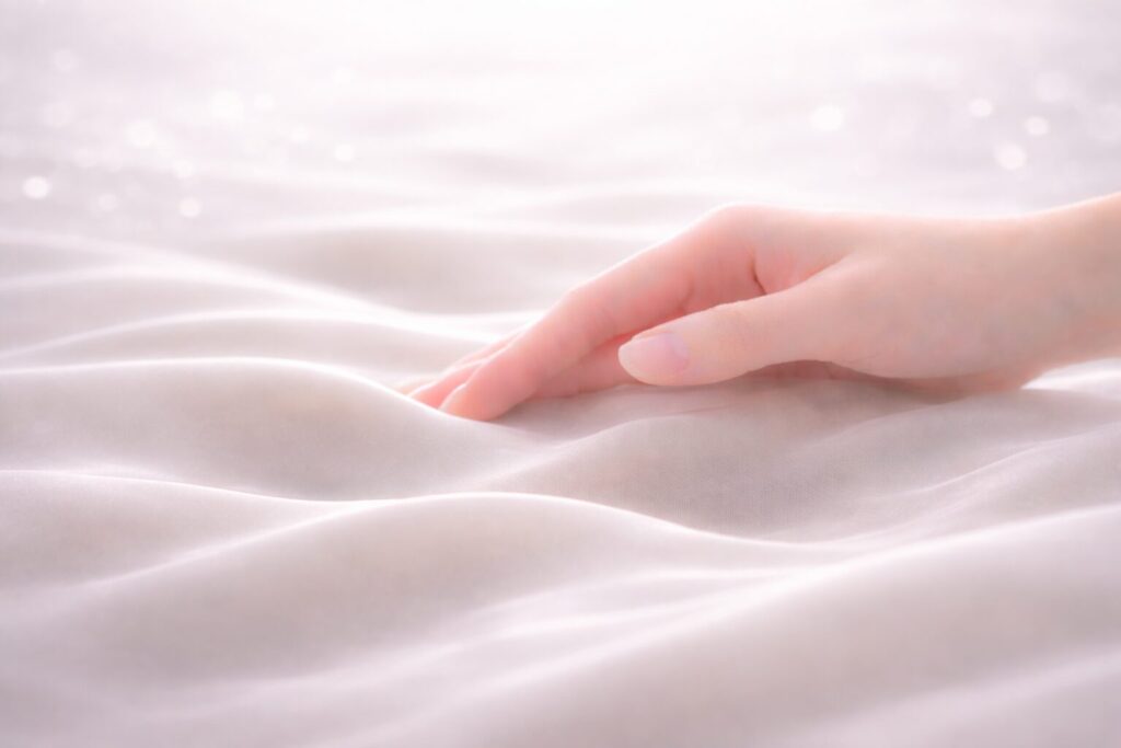 敏感肌にやさしい美容液のなじみをイメージしたシルクと手のビジュアル