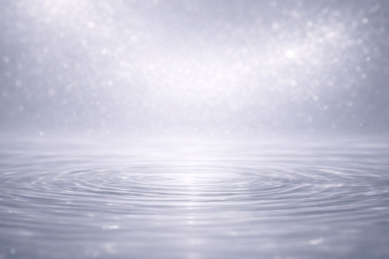 化粧水のうるおい感を連想させる透明な水面と柔らかな波紋の抽象画像